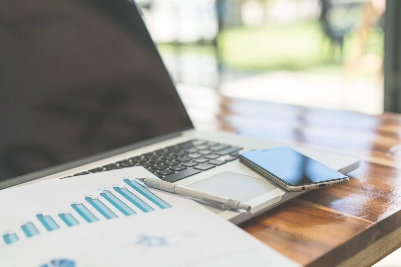 Financial charts on the table with a laptop (filtered image pr).