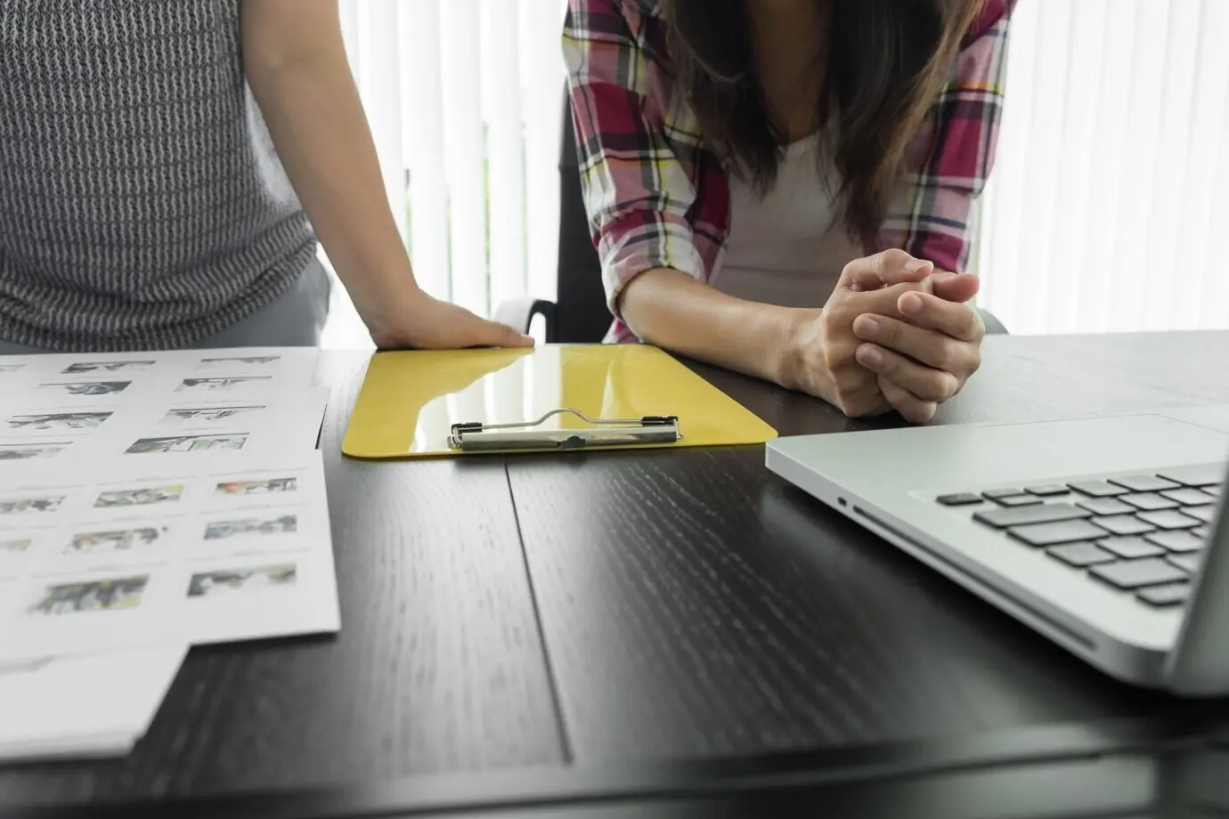 Image of a man's hand pointing at a business document during a meeting discussion.